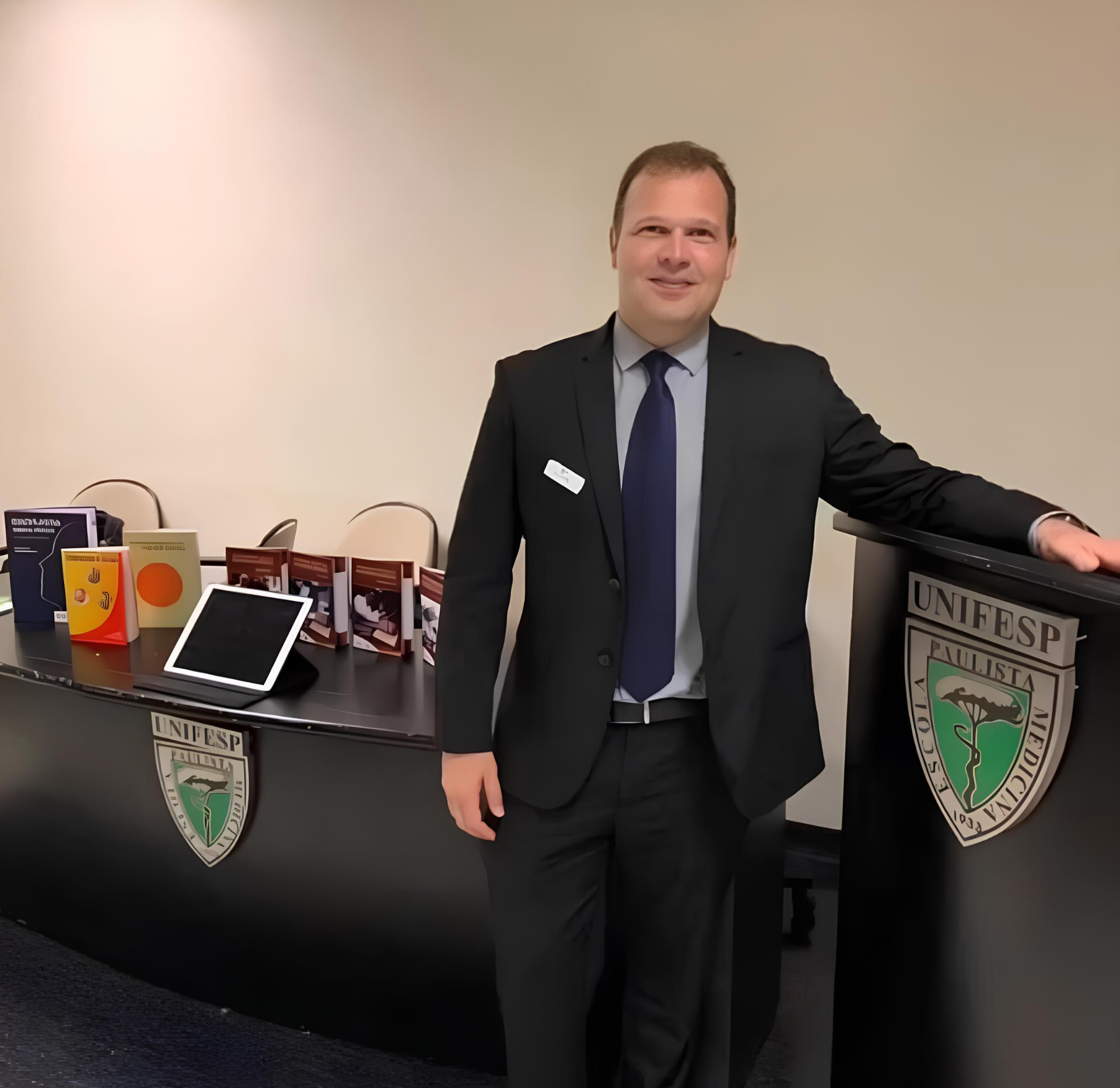 Mauro Castro em apresentação na UNIFESP com livros médicos e tablet